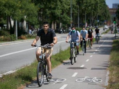 Diverses persones es mouen en bicicleta per un carril bici de Barcelona.