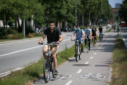 Diverses persones es mouen en bicicleta per un carril bici de Barcelona.