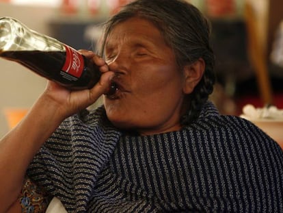 A Mazahua woman drinking Coca-Cola.