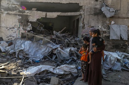 Una mujer mira con sus hijas las ruinas de un edificio destruido tras un ataque israelí este jueves en Ciudad de Gaza, en el norte de la Franja.