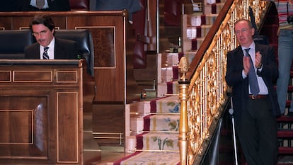 El entonces presidente del Gobierno José María Aznar (i) permanece en su escaño, junto al vicepresidente segundo, Rodrigo Rato, durante el debate sobre el Estado de la Nación en el Congreso de los Diputados del 30 de junio de 2003.