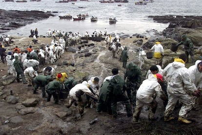 Voluntarios recogiendo fuel en la playa de Cantareira, en las islas Cíes (Pontevedra), procedente del vertido del petrolero "Prestige", 9 de diciembre de 2002.