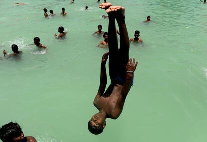 Jóvenes indios juegan en una piscina durante un día caluroso en Chennai (India).