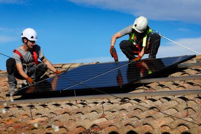 Dos operarios trabajan en el montaje de placas solares para autoconsumo.