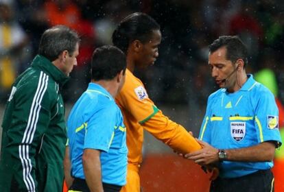 El árbitro uruguayo Jorge Larrionda comprueba la protección de Drogba antes de dejarle saltar al césped.
