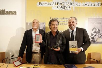 De izquierda a derecha, los escritores Manuel Vicent y Hernán Rivera Letelier, con un libro electrónico en la mano derecha, e Ignacio Polanco, presidente del Grupo PRISA.