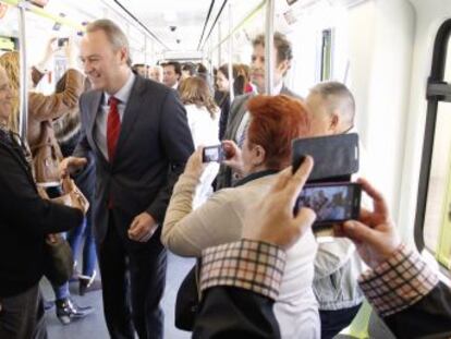 El jefe del Consell, Alberto Fabra, saluda a los viajeros del nuevo tramo de metro de Valencia.