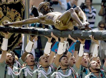 Los legionarios levantan a pulso al Cristo de la Buena Muerte.