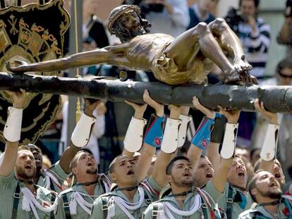 Los legionarios levantan a pulso al Cristo de la Buena Muerte.