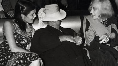 Foto tomada en Studio 54 de Truman Capote flanqueado por Gloria Swanson, a la derecha, y Kate Harrington, hija de un amante de Truman Capote, que el escritor prohijó. / GETTY