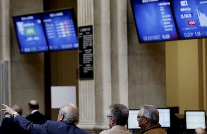 Tres inversores observan las pantallas en el Palacio de la Bolsa de Madrid
