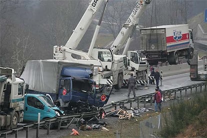 Dos grandes grúas retiran varios de los camiones accidentados ayer en el puerto de Etxegarate.