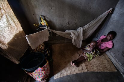 Alinafe, 27 años, sostiene en brazos a Tamanda, su hija de 15 meses, en la habitación del burdel donde ejerce la prostitución. Alinafe no puede dejar a Tamanda a cargo de nadie y suele atender a sus clientes mientras la pequeña duerme a su lado.