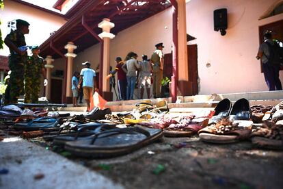 Zapatos de las víctimas siguen en el interior de la iglesia de San Sebastián en Negombo mientras el personal de seguridad inspecciona la zona del suceso, este lunes.