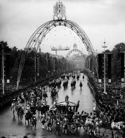 Elizabeth II's carriage rides through the streets of London in front of thousands of cheering citizens after her coronation.