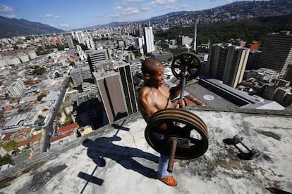 El fotógrafo Jorge Silva retrata el interior del rascacielos más grande de Caracas, un edificio a medio construir que se levanta en el centro de la ciudad, resultado del abandono financiero, y que se ha convertido en un barrio para cerca de 3.000 personas. En la imagen, Gabriel Rivas, de 30 años, ejercita sus músculos en un balcón de la planta 28.