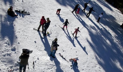 Niños madrileños comienzan sus primeros pinitos sobre los esquís en Navacerrada.