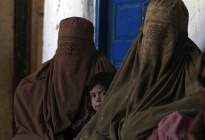 Una niña espera para recibir medicamentos gratuitos acompañada de su madre y otra mujer, en un campamento médico establecido por la organización Jamaat-ud-Dawa para atender a los afectados por el terremoto en la aldea Rehankot, en el distrito de Alto Dir (Pakistán).