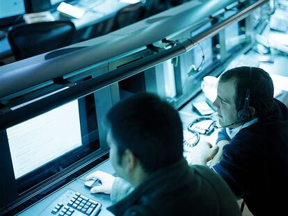 Empleados de una corporación analizan datos para la protección de clientes ante ataques de piratas informáticos.