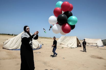Una mujer palestina suelta globos al aire como parte las protestas en Rafah, en la frontera entre Israel y Gaza, al sur de la franja de Gaza.