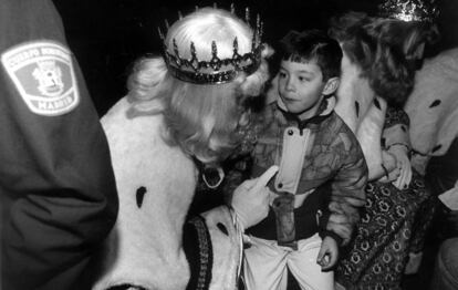 Un niño atiende los consejos del rey Melchor en la fiesta de los Reyes Magos de los hijos del cuerpo de Bomberos de Madrid en 1991