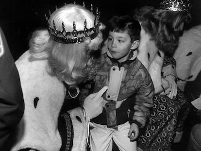 Un niño atiende los consejos del rey Melchor en la fiesta de los Reyes Magos de los hijos del cuerpo de Bomberos de Madrid en 1991