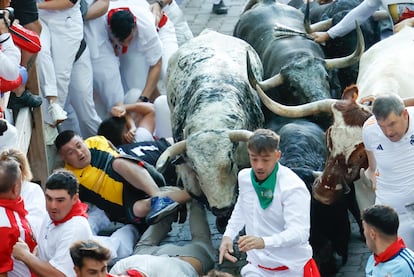Varios corredores caen al suelo durante la segunda carrera de las fiestas de San Fermín, este martes.