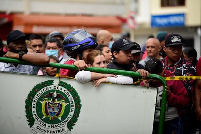 Con el paso de las horas, han llegado al exterior de la cárcel más y más familiares de los reclusos. En la imagen, familiares esperan junto a uno de los cercos puestos por la policía en el acceso principal al centro penitenciario.