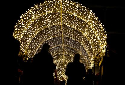 Varias personas pasean bajo una instalación de luces durante la celebración del Ramadán en Dubái (Emiratos Árabes Unidos).