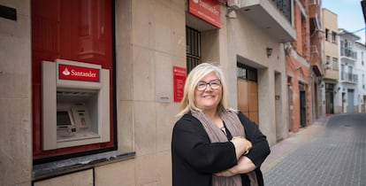 La alcaldesa de Castellnovo (Castellón), Carmina Gil, ante el único y último banco de su municipio, que acaba de echar el cierre. 