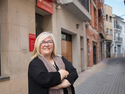 La alcaldesa de Castellnovo (Castellón), Carmina Gil, ante el único y último banco de su municipio, que acaba de echar el cierre. 