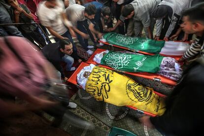 El cuerpo sin vida de Rafat Ayad y los de sus dos hijos en el este de la ciudad de Gaza, asesinados por un ataque aéreo israelí. 
