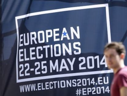 Transeuntes passam por cartaz alusivo às eleições europeias, em Bruxelas.