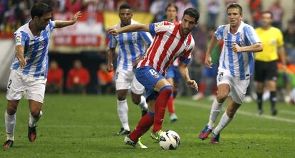 Raúl García controla el balón en el duelo liguero ante el Málaga, entre Eliseu y Camacho