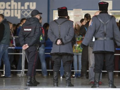 Un par de cosacos y un policía rusos patrullan por el aeropuerto Adler de Sochi (Rusia)