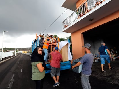 Una familia desalojada carga sus pertenencias en una camioneta en Los Llanos, La Palma.