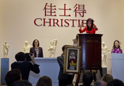 Un empleado muestra la obra 'Homme Assis' (1969), del artista español Pablo Ruiz Picasso, durante la primera subasta de Christie's en China.