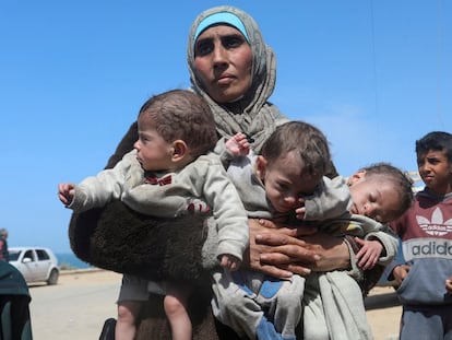 Una mujer palestina huye del hospital de Al Shifa después de una redada israelí con sus hijos trillizos.