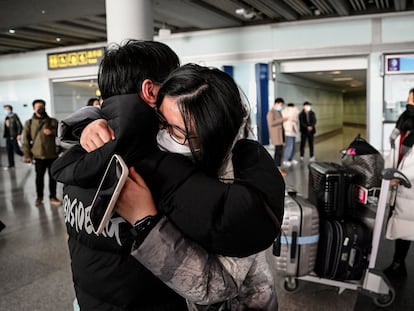 Dos personas se abrazan este domingo en la zona de llegadas en el aeropuerto internacional de Pekín.