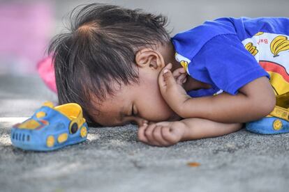 Un niño duerme a las afueras de un campamento improvisado en Palu.  