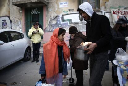 Varias personas reciben comida en un centro de ayuda humanitaria en el centro de Atenas.