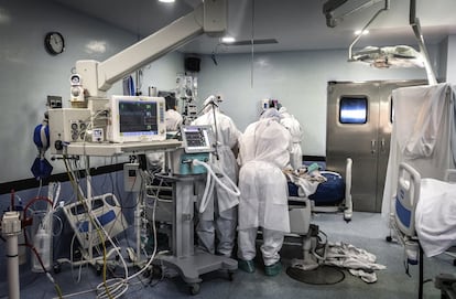 Personal sanitario atiende a un paciente ingresado por coronavirus en la sala de quirófano acondicionada como UCI.