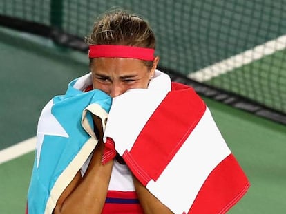 Puig celebra su triunfo envuelta en una bandera de su pa&iacute;s.