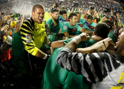 Víctor Valdés (l) and his Barcelona teammates celebrate after a 1-1 tie at Levante secured their third straight Liga triumph.