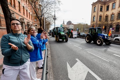 Varia personas aplauden la entrada de los tractores a Madrid a su paso por la calle O'Donnell. 
