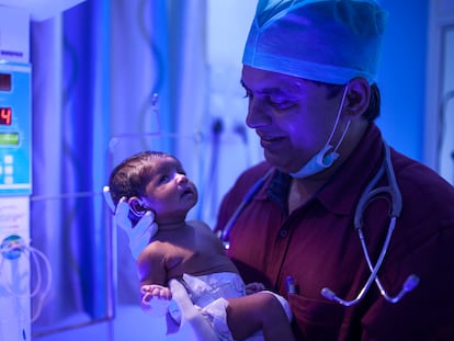 El doctor Rakh sostiene a una de sus recién nacidas.