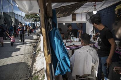 El campo de refugiados de Moria, que en principio fue concebido como un centro de registro de solicitantes de asilo, se ha convertido en una pequeña ciudad, que requiere de recursos básicos como tiendas, puestos de venta ambulante, pequeñas teterías o cafeterías regentadas por refugiados para obtener algunos ingresos. En la imagen, una peluquería ubicada junto a una de las entradas del recinto.