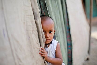 Una niña refugiada Rohingya se asoma en una tienda de campaña en un campamento en Nueva Delhi (India).