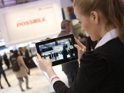 Una empleada muestra una tableta en el tercer d&iacute;a del Mobile World Congress.