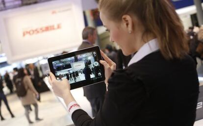 Una empleada muestra una tableta en el tercer d&iacute;a del Mobile World Congress.